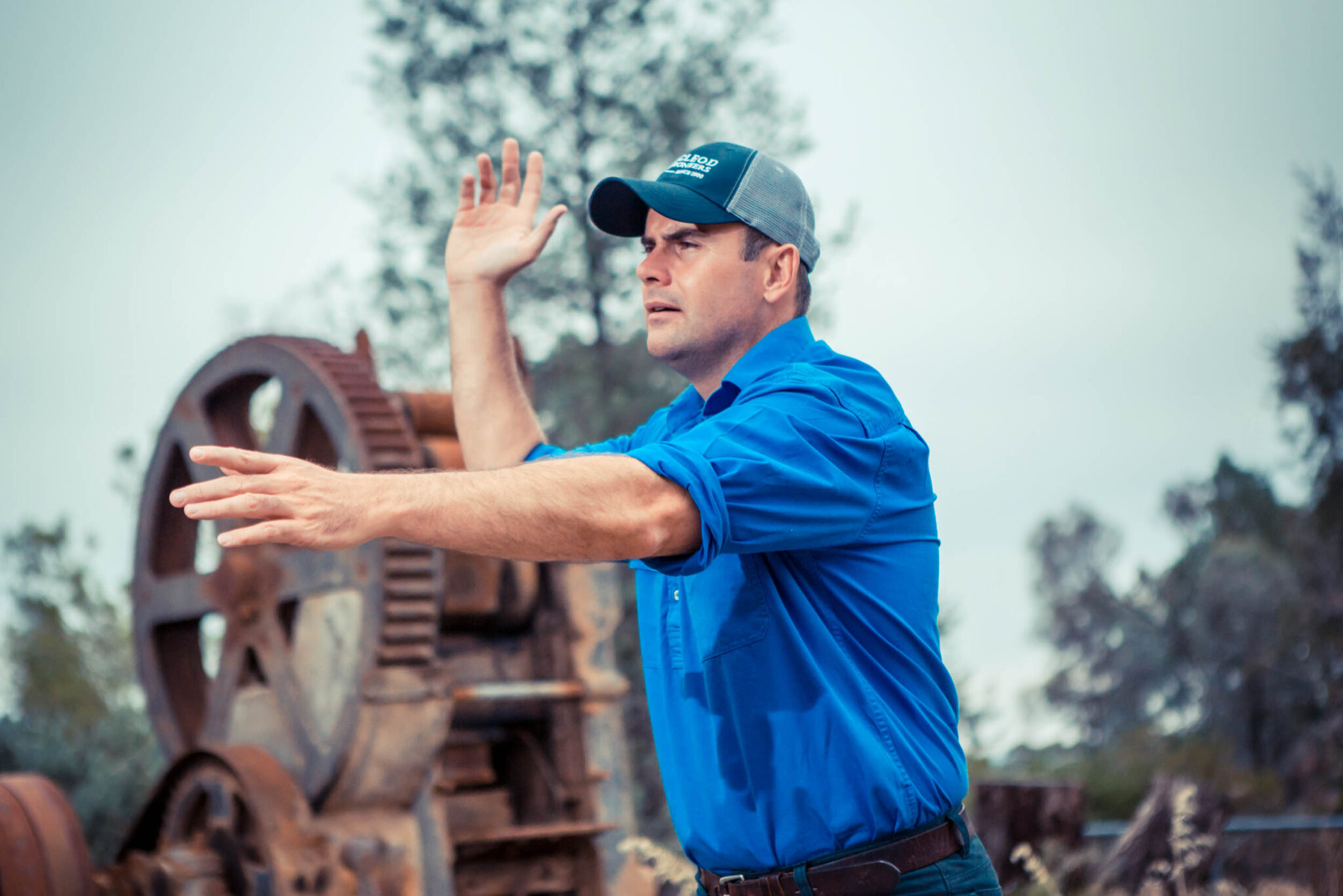 Angus Macleod calling a clearing sale beside farm machinery